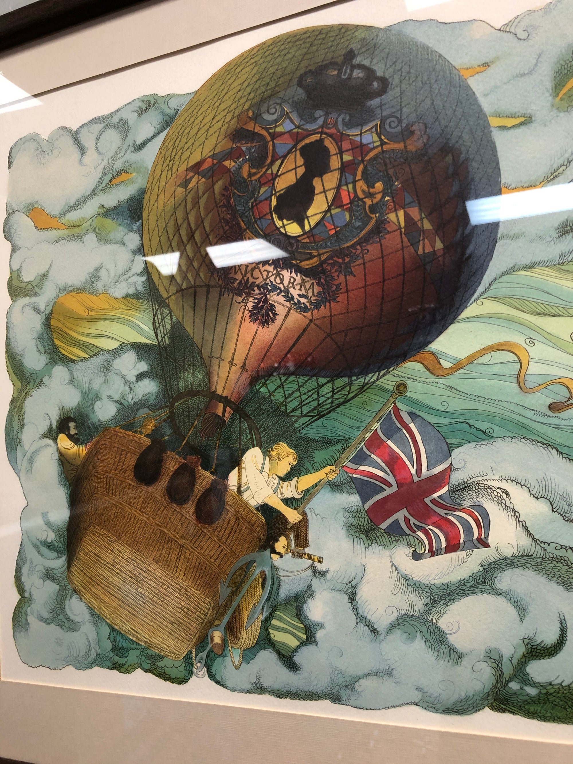 A colorful original lithograph artwork depicting a whimsical scene with a hot air balloon, people, and various objects, framed in a simple brown frame.
